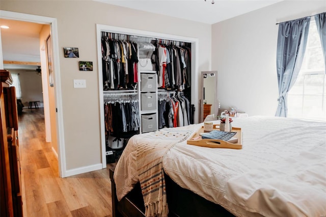 bedroom featuring a closet, light wood-style floors, and baseboards