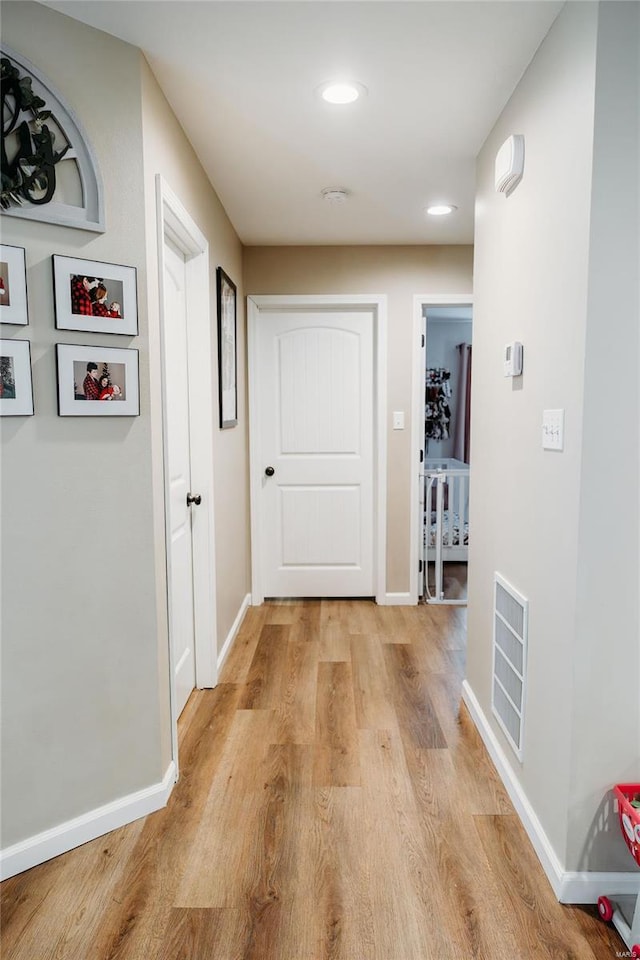 corridor with baseboards, recessed lighting, light wood-style flooring, and visible vents