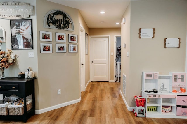 hallway with recessed lighting, baseboards, and light wood-type flooring