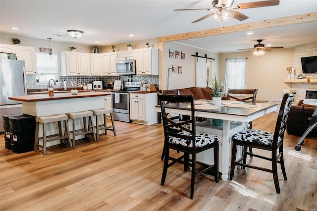 dining area featuring recessed lighting, a ceiling fan, light wood-type flooring, and a wealth of natural light