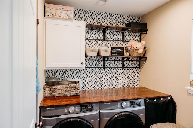laundry room with washing machine and dryer and cabinet space