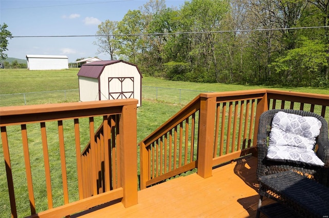 wooden terrace with a yard, an outdoor structure, a fenced backyard, and a shed