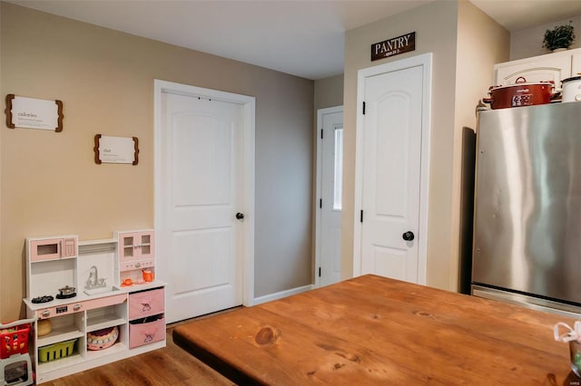 game room with baseboards and wood finished floors