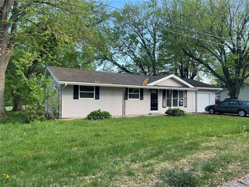 ranch-style house featuring an attached garage and a front lawn