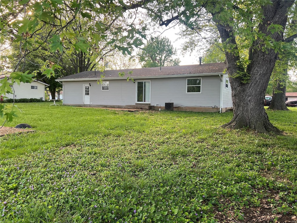back of house featuring entry steps and a yard