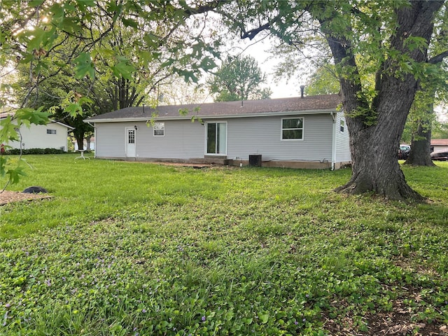 back of house featuring entry steps and a yard