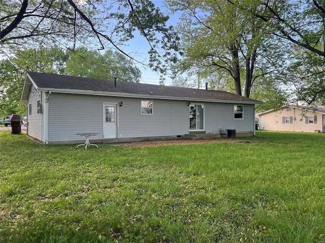 rear view of property with central air condition unit, a yard, and entry steps