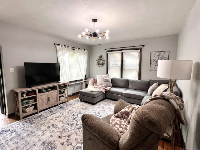 living room with light wood finished floors and an inviting chandelier
