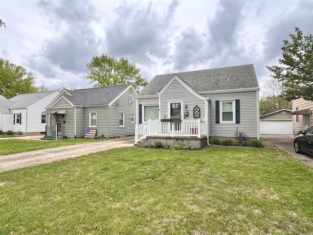 view of front of house with a front yard, an outbuilding, and a shingled roof