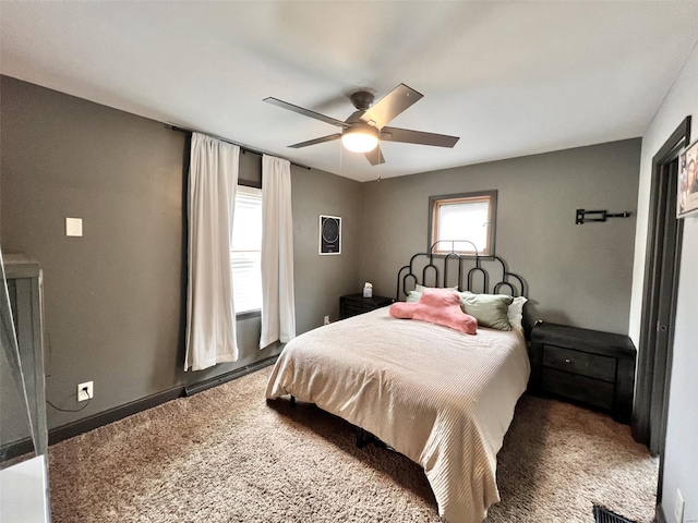 carpeted bedroom with a baseboard heating unit and a ceiling fan