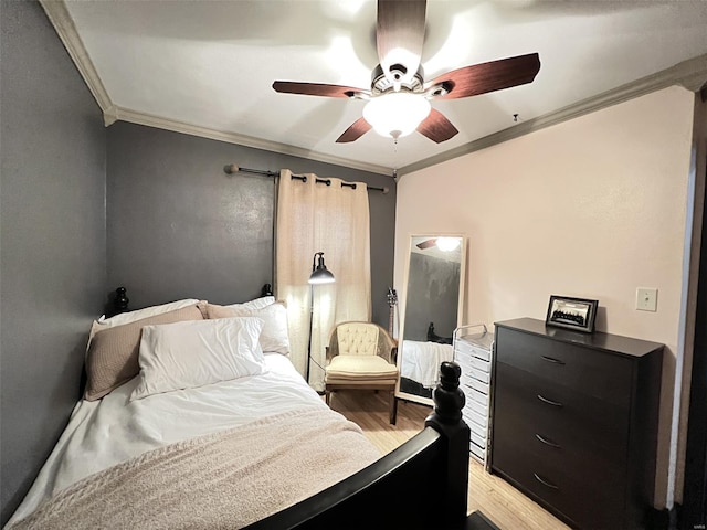 bedroom featuring crown molding, light wood-type flooring, and a ceiling fan