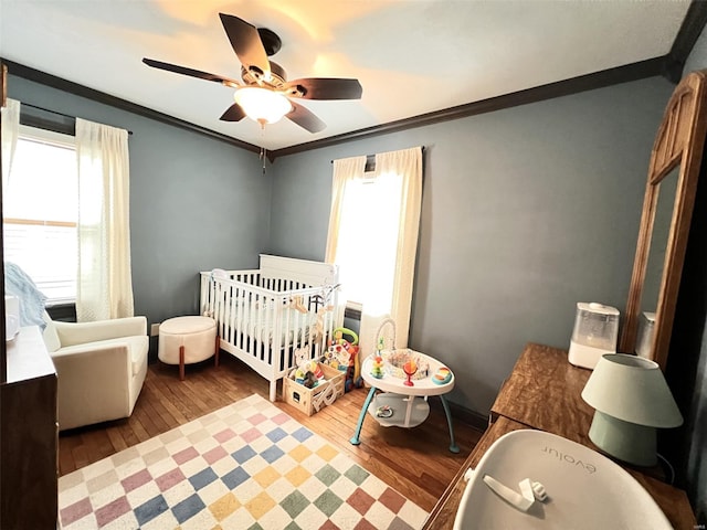 bedroom featuring multiple windows, wood-type flooring, and crown molding