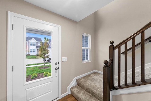 foyer with baseboards, plenty of natural light, and stairway