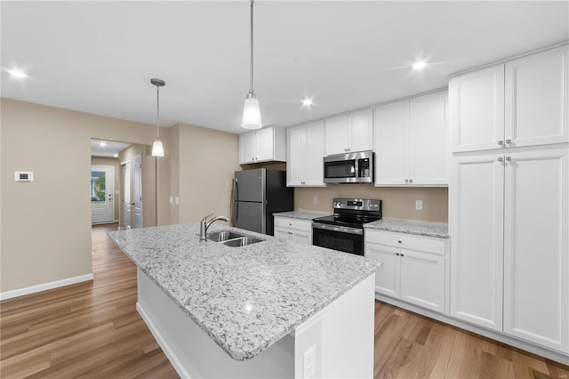 kitchen featuring a sink, white cabinets, light wood-style floors, and stainless steel appliances