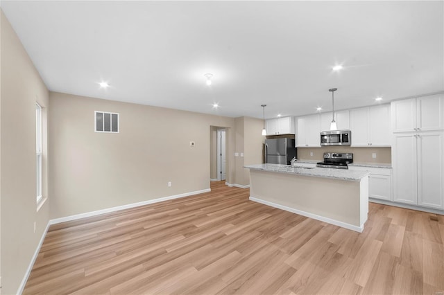 kitchen with white cabinets, baseboards, appliances with stainless steel finishes, and visible vents