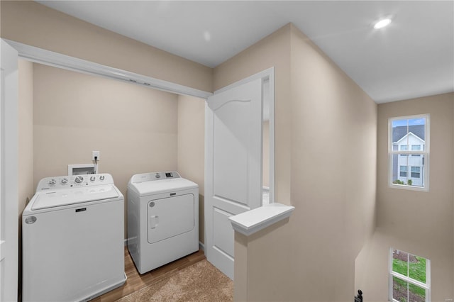 clothes washing area featuring independent washer and dryer, laundry area, and light wood-type flooring
