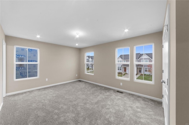 empty room featuring baseboards, recessed lighting, carpet, and visible vents