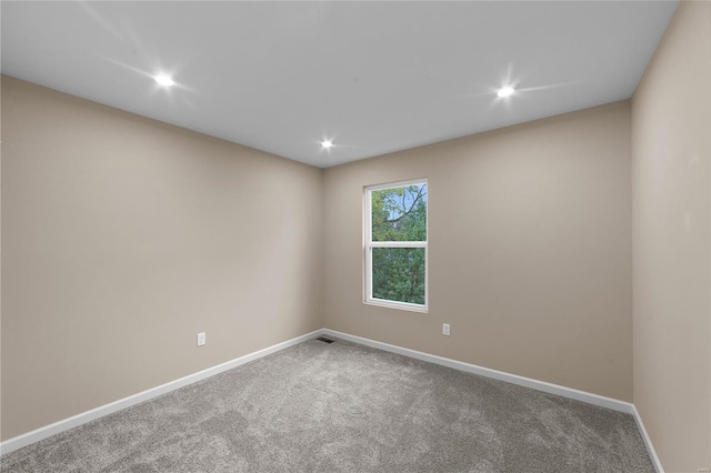 carpeted spare room featuring recessed lighting, baseboards, and visible vents