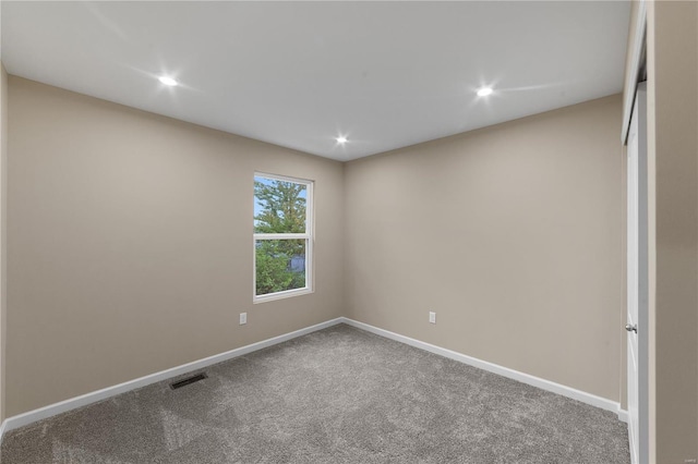 spare room featuring baseboards, recessed lighting, carpet floors, and visible vents