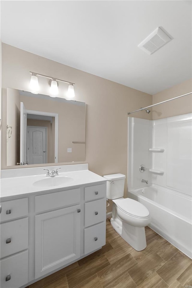 bathroom featuring vanity, shower / bathtub combination, toilet, and visible vents