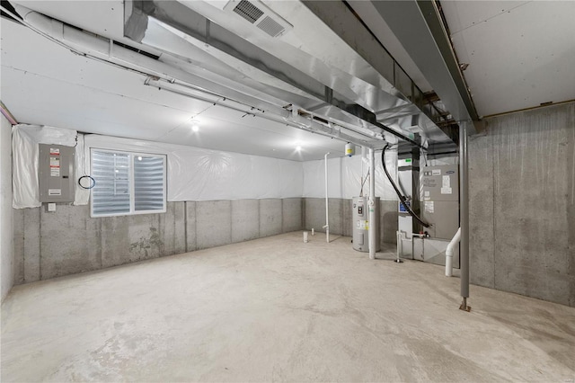 unfinished basement featuring electric water heater, electric panel, and visible vents