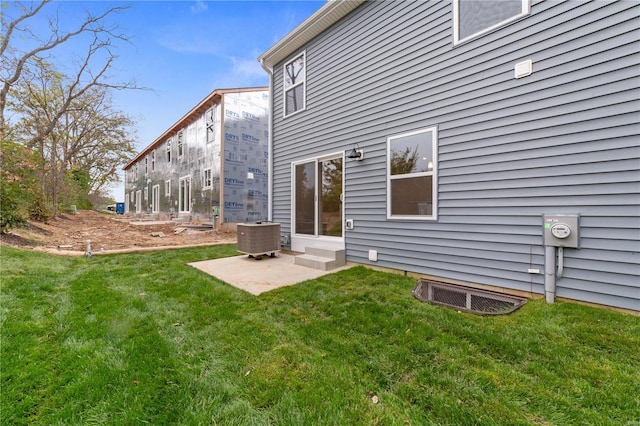 back of property with a lawn and central AC