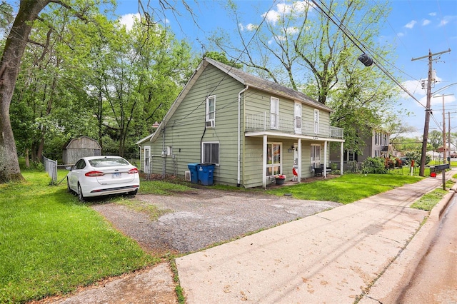 view of front facade with a storage unit, an outdoor structure, and a front lawn