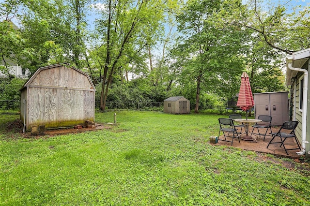 view of yard featuring a fenced backyard, a shed, and an outbuilding