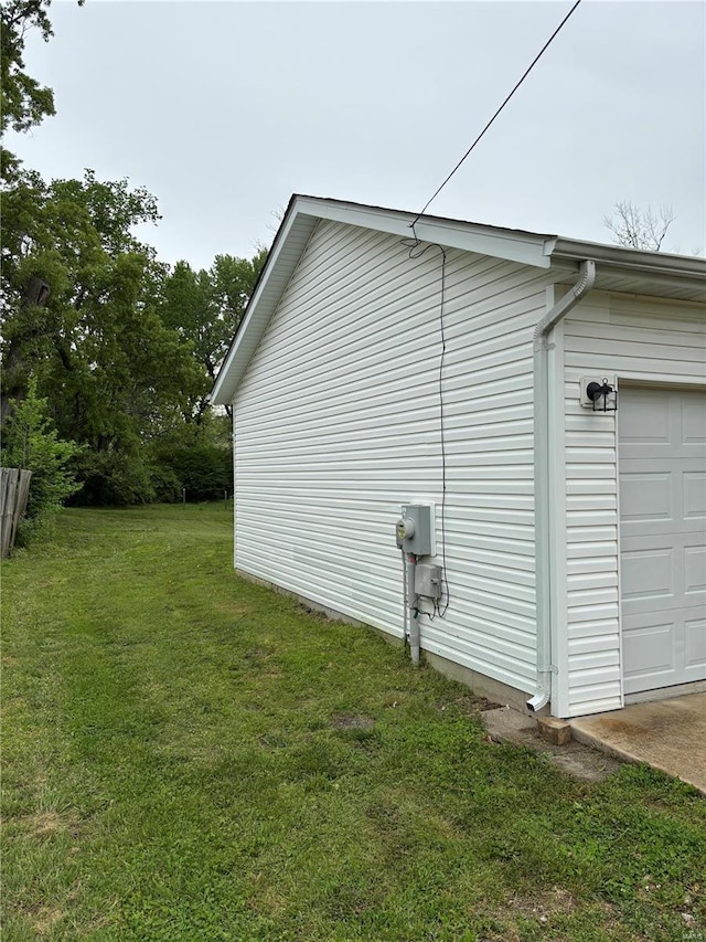 view of side of property with a lawn and a garage