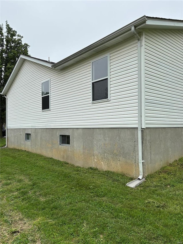 view of side of property with a lawn and crawl space