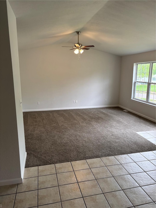 spare room with baseboards, a ceiling fan, lofted ceiling, and light colored carpet