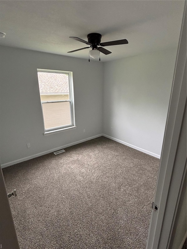 unfurnished room featuring carpet floors, baseboards, ceiling fan, and visible vents
