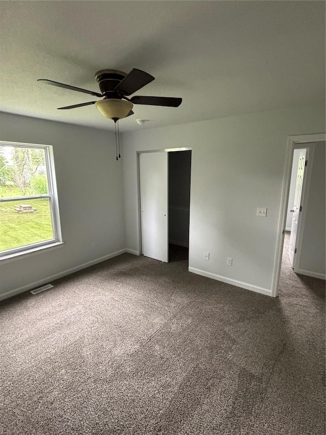 unfurnished bedroom featuring baseboards, carpet, visible vents, and a closet