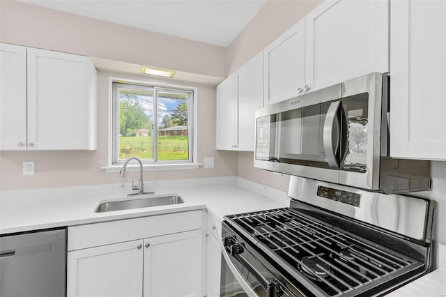 kitchen with light countertops, white cabinetry, appliances with stainless steel finishes, and a sink