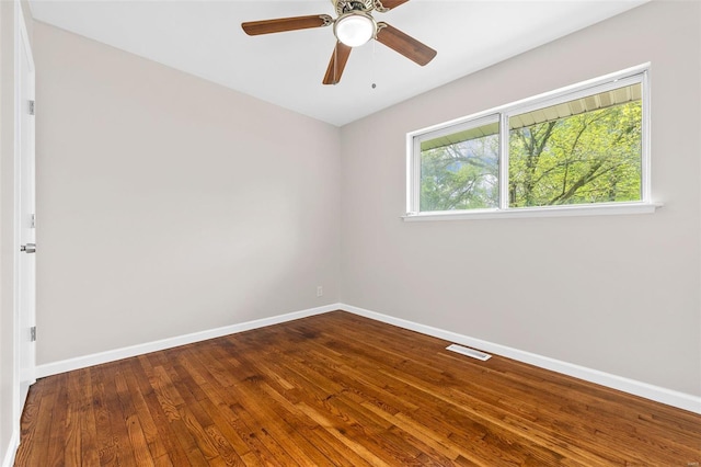 empty room featuring visible vents, a ceiling fan, baseboards, and hardwood / wood-style flooring