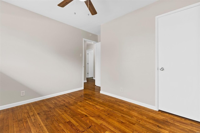 spare room with baseboards, ceiling fan, and wood finished floors