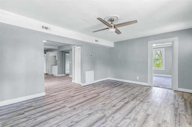 spare room featuring baseboards, a ceiling fan, wood finished floors, and visible vents