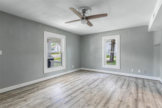 empty room with baseboards, a ceiling fan, and wood finished floors