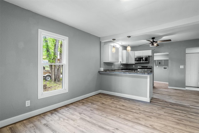 kitchen featuring baseboards, white cabinets, stainless steel appliances, and light wood-style flooring