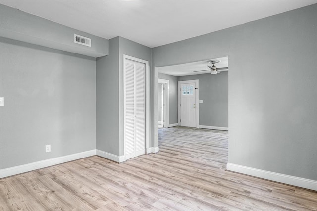 unfurnished room featuring visible vents, a ceiling fan, baseboards, and wood finished floors