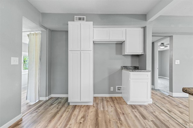 kitchen featuring white cabinetry, baseboards, visible vents, and light wood finished floors