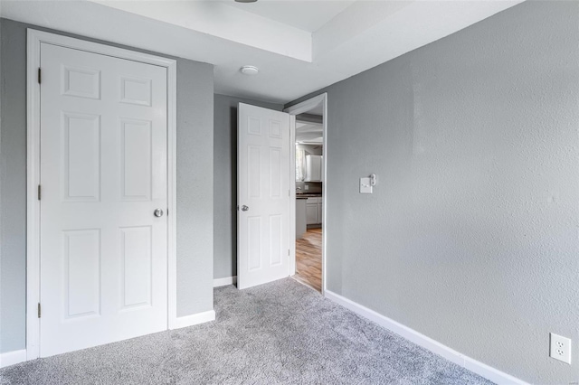 unfurnished bedroom with carpet flooring and baseboards
