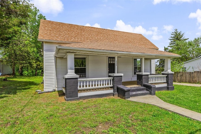 bungalow-style home featuring a porch, roof with shingles, and a front yard