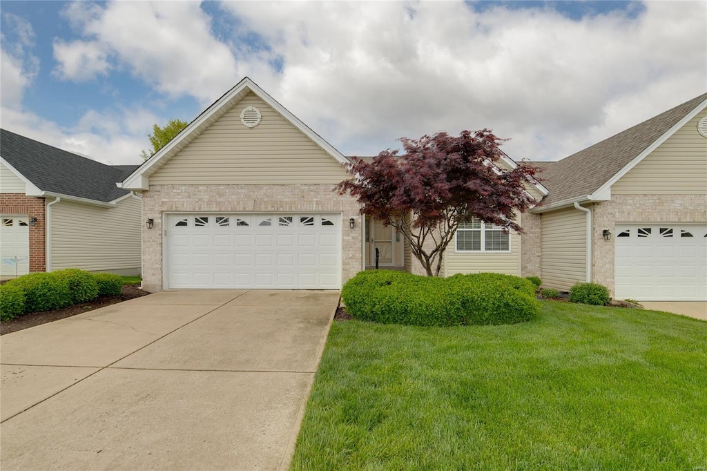 ranch-style home with a garage, a front lawn, roof with shingles, brick siding, and driveway