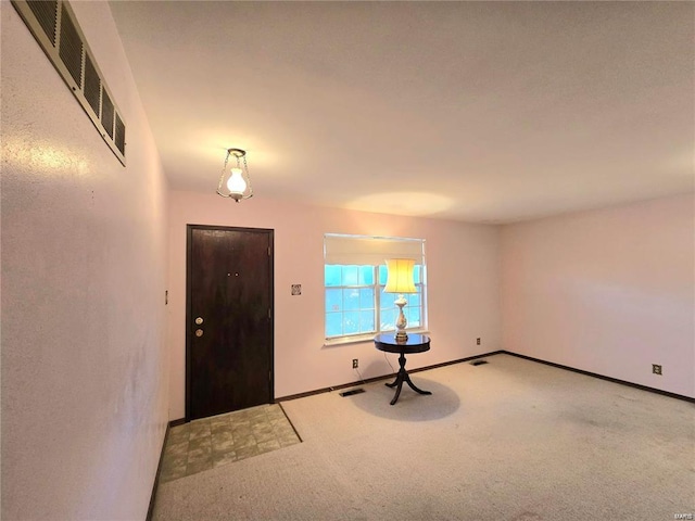 foyer with baseboards, carpet flooring, and visible vents