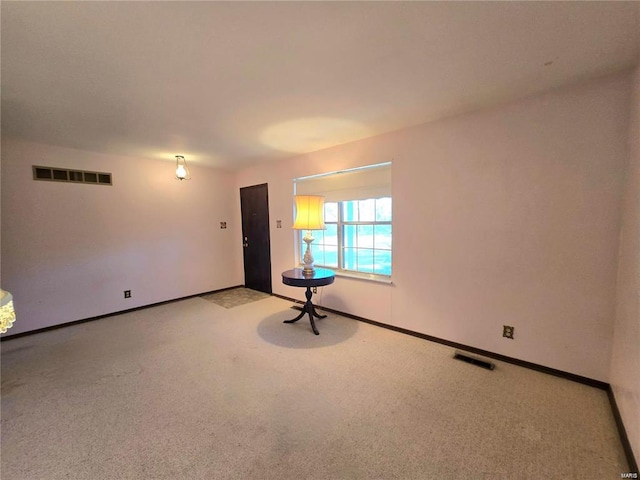 carpeted empty room featuring baseboards and visible vents
