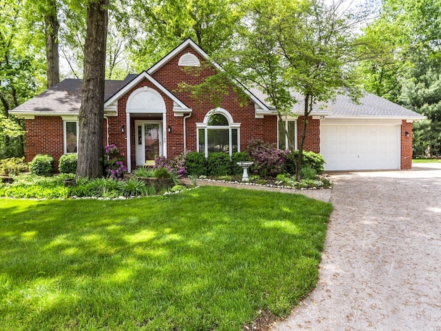 ranch-style home with brick siding, a garage, driveway, and a front lawn