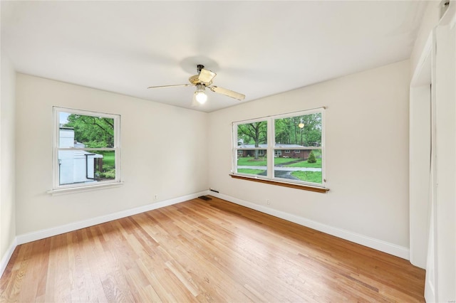 spare room with light wood-style flooring, baseboards, and a ceiling fan