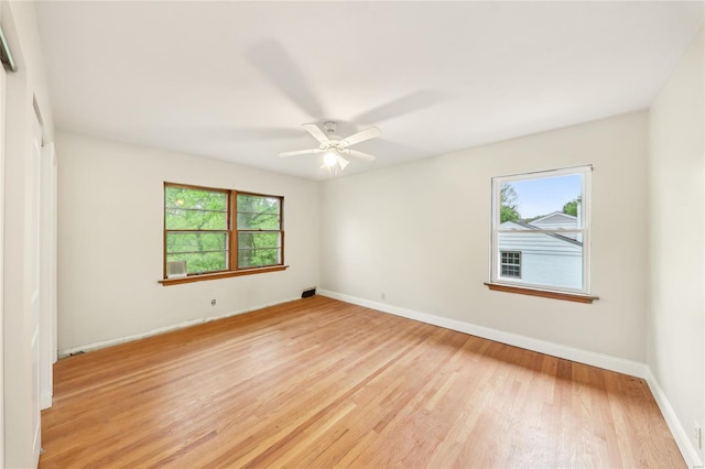 spare room with light wood finished floors, baseboards, and a ceiling fan