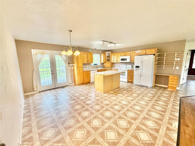 kitchen with light countertops, plenty of natural light, french doors, and white appliances